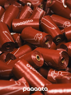 Red rolls of dog waste bags with 'paaaata' branding on a pile.