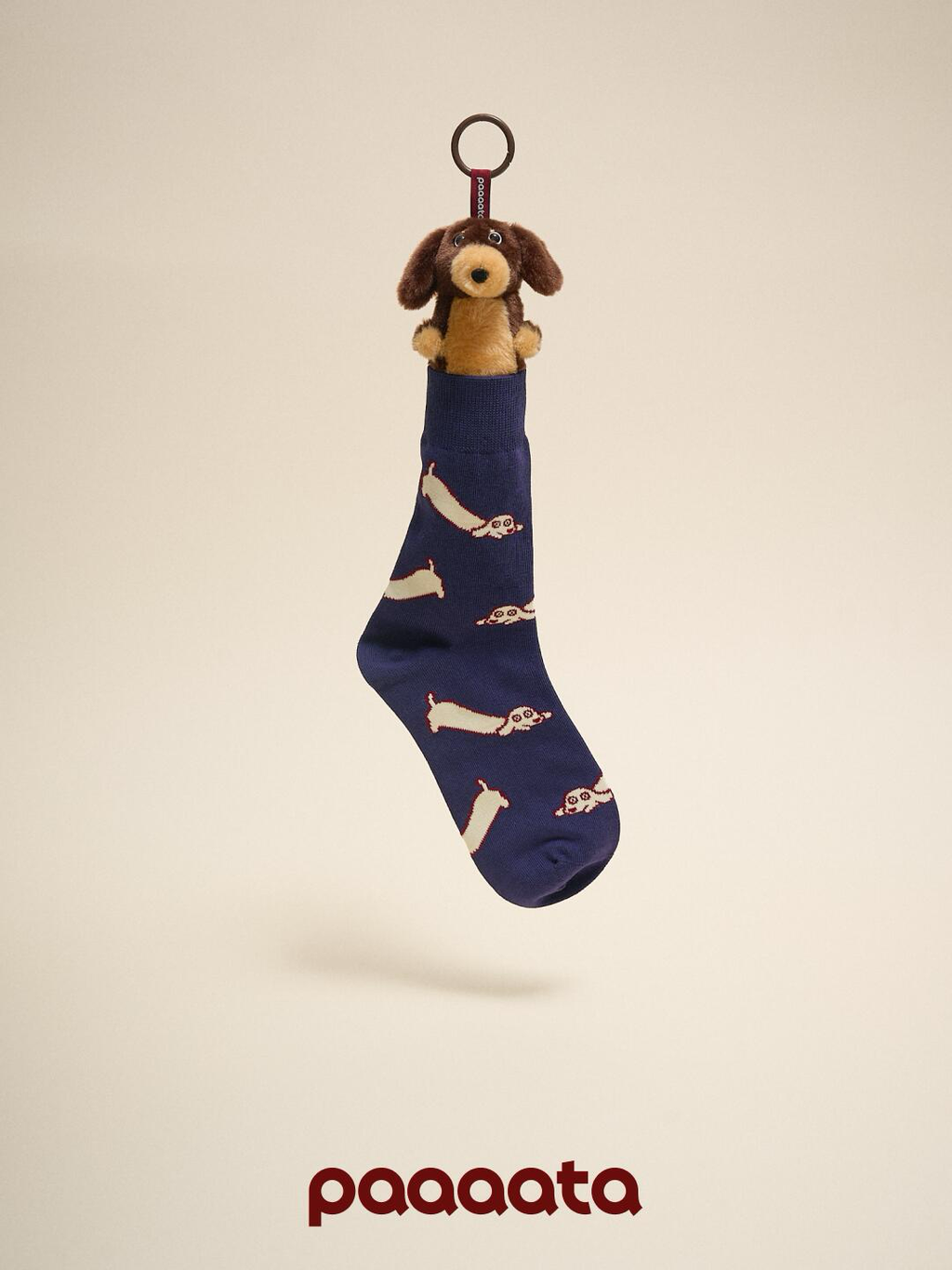 Navy blue sock with dachshund pattern and plush dog toy on beige background
