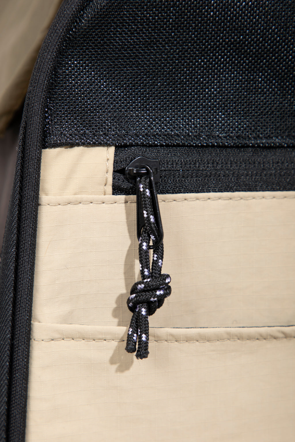 Close-up view of the pet backpack carrier zipper detail along the mesh edge, showing the corded zipper pull and seam finish.