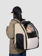 Person wearing an expandable pet carrier backpack with a cat looking out from the front window, showing the ventilated mesh panel and large backpack shape.