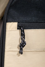 Close-up of the zipper pull and mesh panel on a pet carrier backpack, showing reinforced stitching and ventilated nylon mesh.