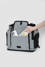 Back view of a pet flight carrier with a large storage pocket holding a phone and travel items for easy access.