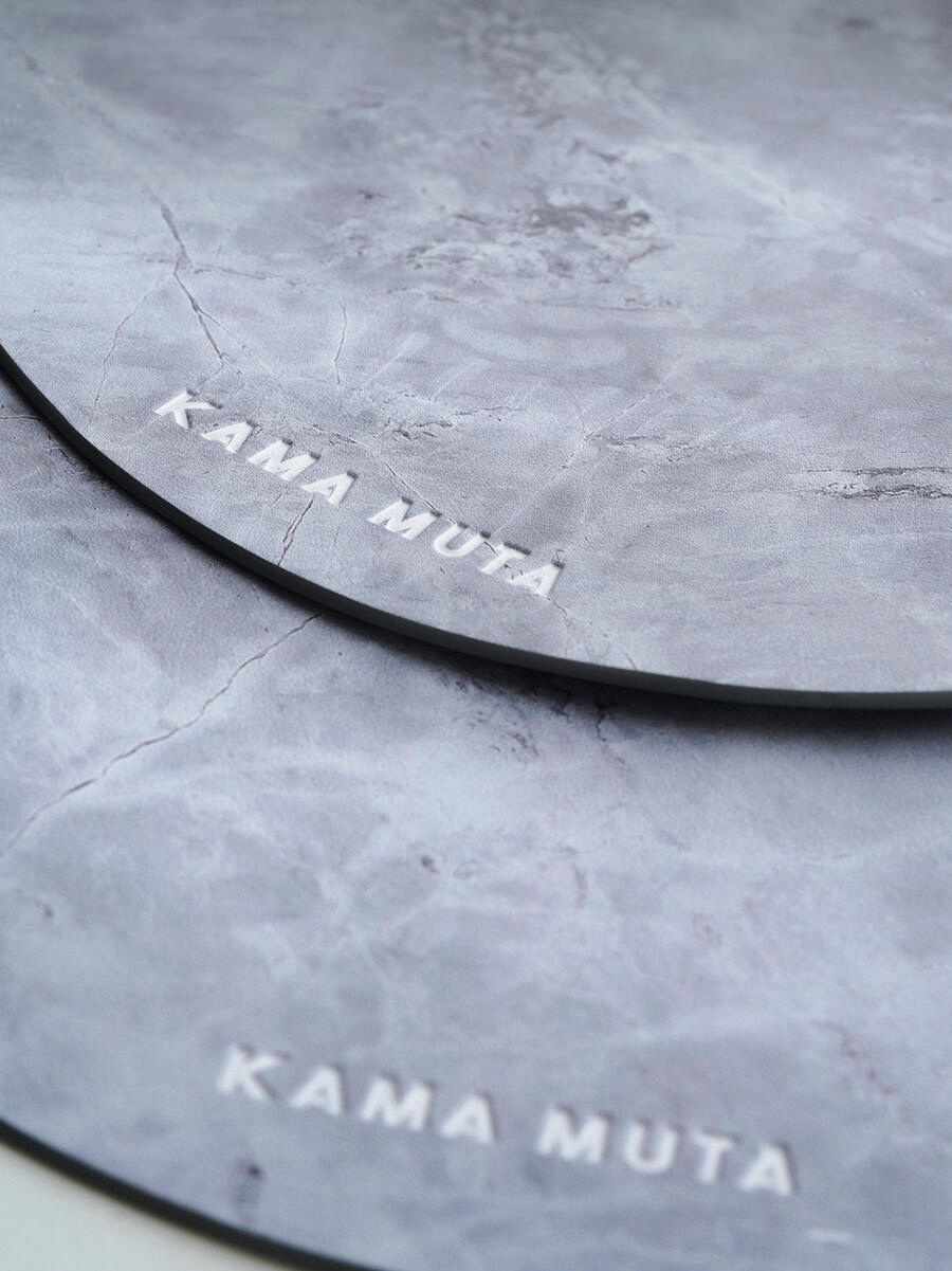 Grey scratch-resistant placemat set stacked together, showing durable surface for pet bowls and tableware.