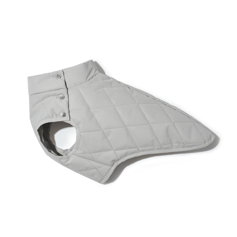 Flat lay of a grey quilted dog vest highlighting color variation and panel construction
