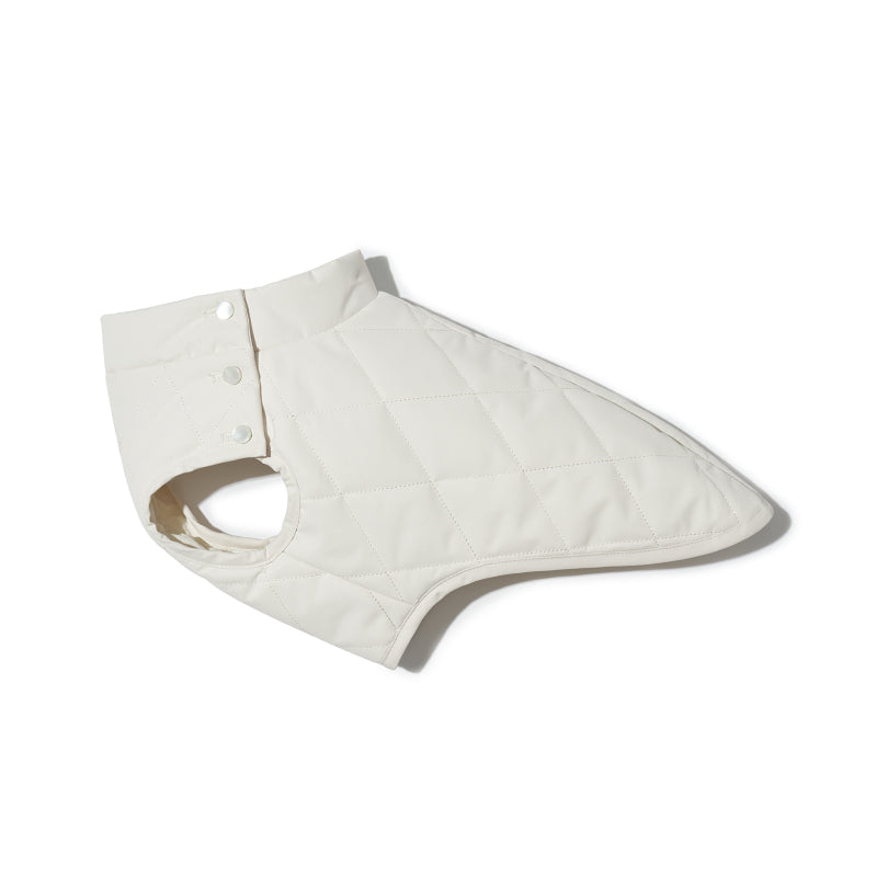 Flat lay of a white quilted dog vest showing overall shape, sleeveless cut, and stitching