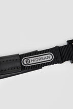 Close-up of brand logo patch on black webbing of a slip dog leash, showing woven nylon detail and stitched finish.