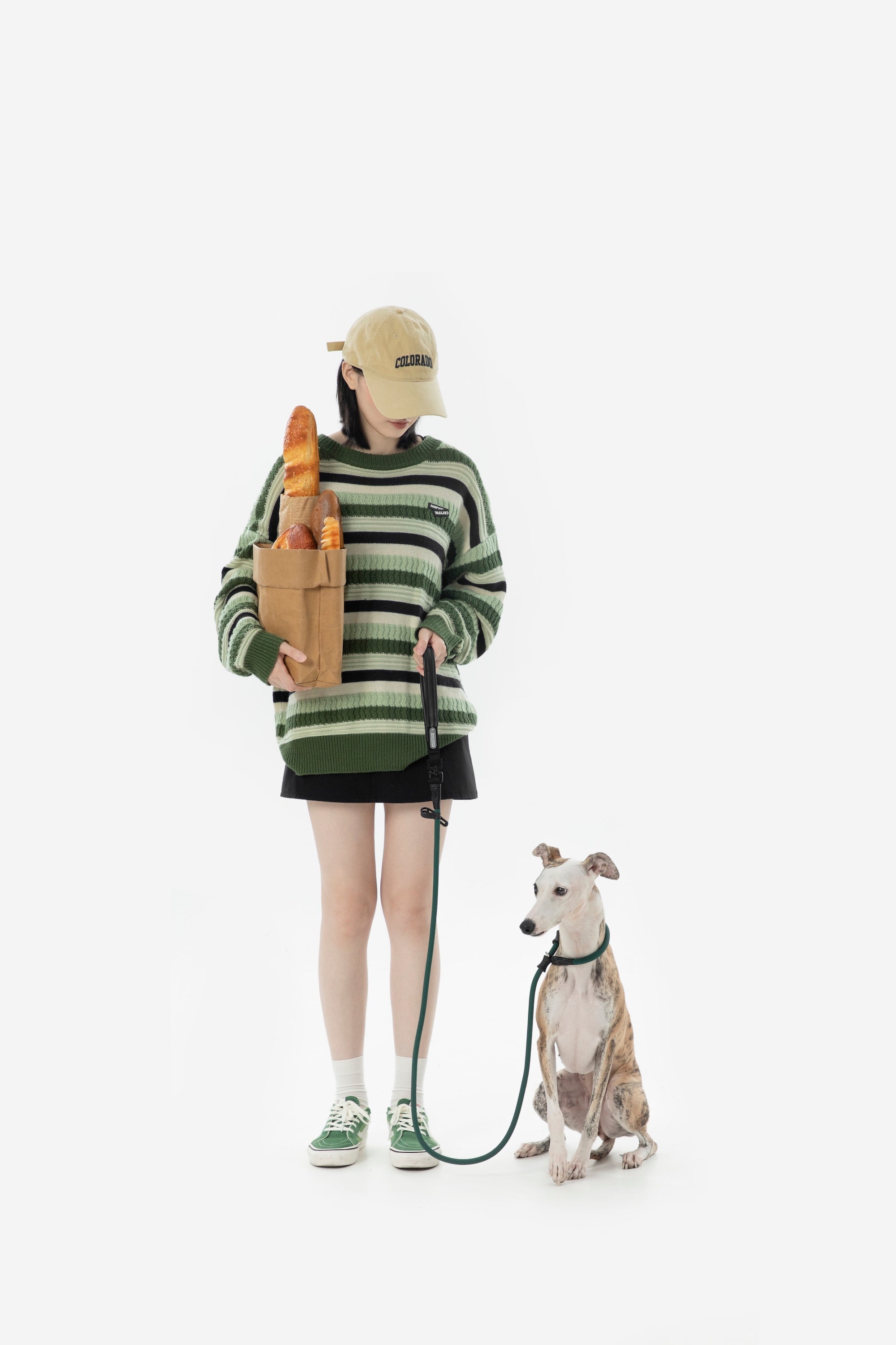 Full-body studio lifestyle shot of a handler and dog using a slip dog leash, showing the leash length and everyday walking setup.