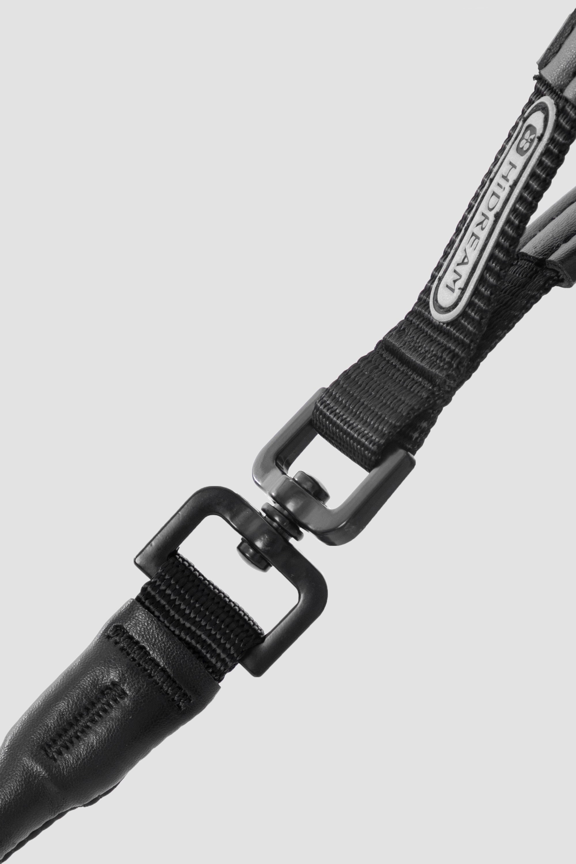 Detail shot of the swivel hardware clip on a dog leash, showing the sturdy connection between webbing and metal buckle.