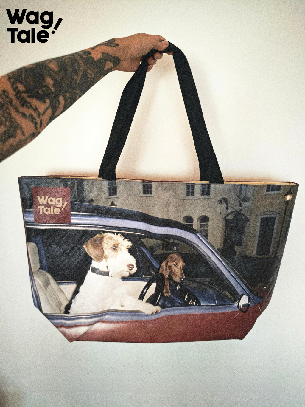 A water-resistant large tote bag held up by the handles, showing the printed dog-in-car graphic on the front panel and wide cotton webbing straps.