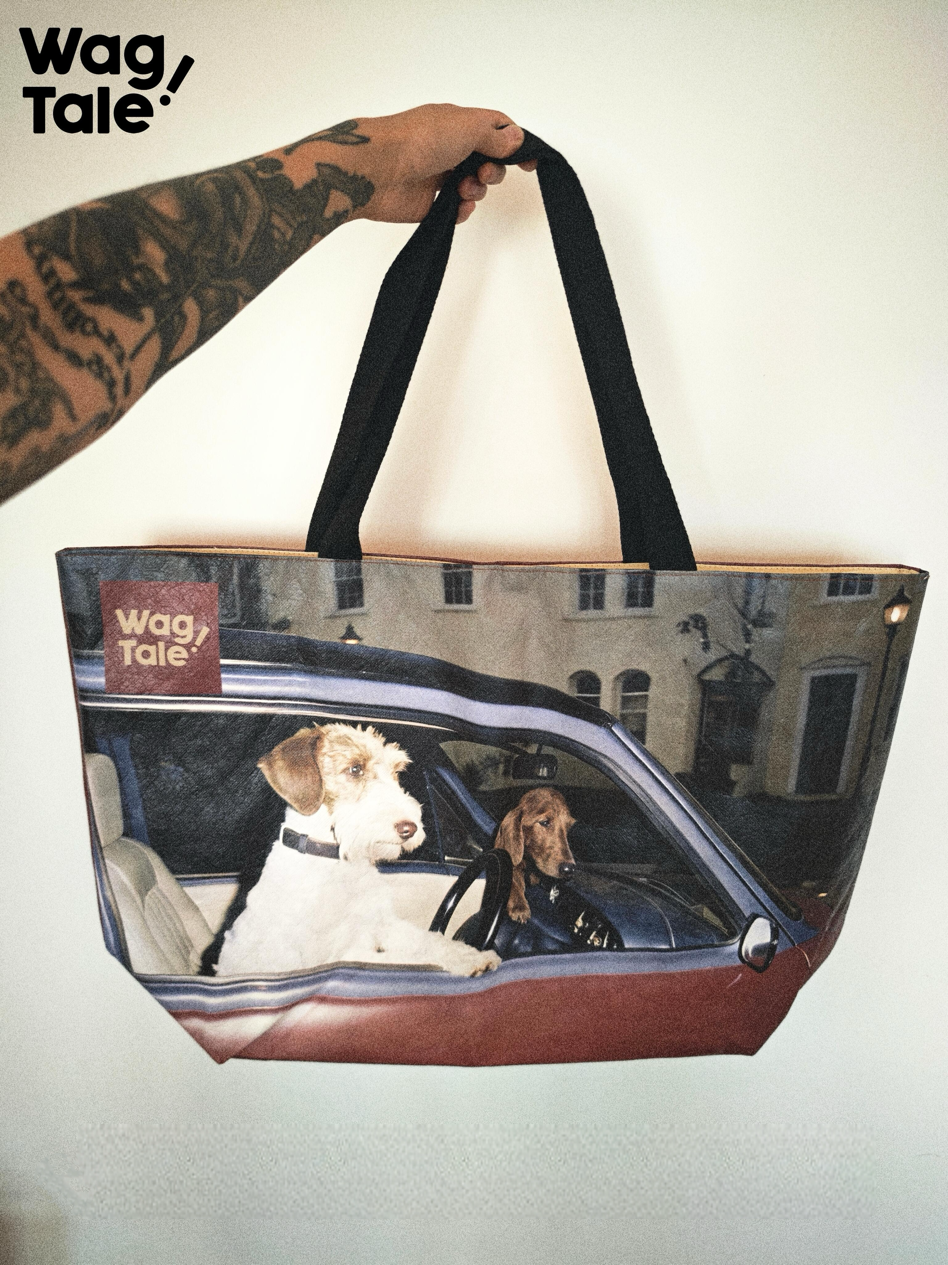 A water-resistant large tote bag held up by the handles, showing the printed dog-in-car graphic on the front panel and wide cotton webbing straps.