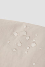 Close-up of water droplets on the nylon fabric of a dog treat pouch, showing the water-resistant surface and fabric texture.