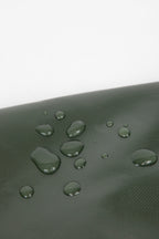 Close-up of water droplets on the surface of a cat carrier tote, demonstrating the water-resistant Oxford fabric texture.
