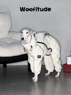 Italian Greyhound standing indoors wearing a cream winter dog down suit showing full-body fit and flexible leg coverage.